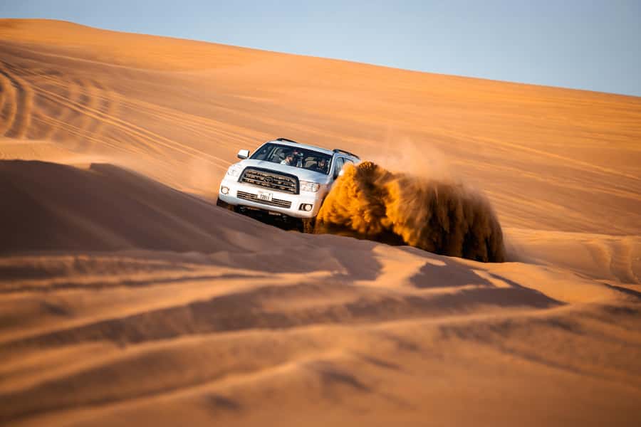 Dubai: Premium Red Dune Safari with Sandboarding & BBQ - Sandboarding and a sunset photo stop
