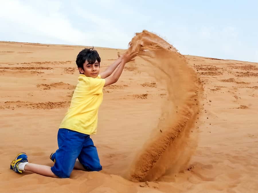 Dubai: Red Dune Safari, Quad Bike, Camel Ride, BBQ Dinner - Sandboarding turns the dunes into a playground