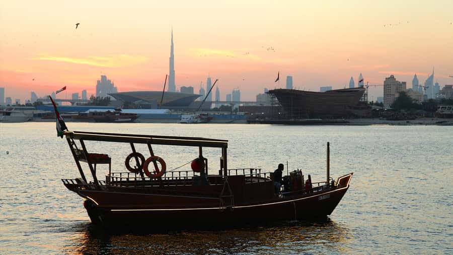 Dubai: Sunset Cruise on Traditional Boat & Emirati High Tea - A Traditional Abra Against Dubai’s Modern Skyline